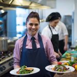 young waitress showing dishes of tasty meals